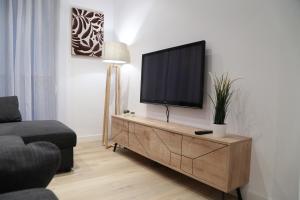a living room with a flat screen tv on a cabinet at Zurriola beach brand new apartment by Cisan Rentals in San Sebastián