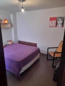 a bedroom with a purple bed and a chair at Casabunda Multiespacio, habitación privada en el centro in Salta