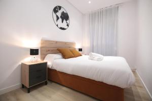 a bedroom with a large bed with a wooden headboard at Zurriola beach brand new apartment by Cisan Rentals in San Sebastián