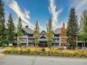 an exterior view of a large house with trees at The Eden Whistler - Luxury 2 BDRM Ski in / Ski out in Whistler