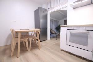 a small kitchen with a table and a refrigerator at Zurriola beach brand new apartment by Cisan Rentals in San Sebastián