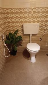 a bathroom with a toilet and a plant at Kailani boutique stay in Varkala