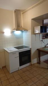 a small kitchen with a stove and a microwave at Le Gîte du Hérisson, Gîte de charme et de confort in Le Menoux