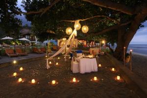 a table set up under a tree with candles at Living Asia Resort and Spa in Senggigi +37 photos