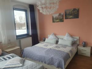 a bedroom with a bed and a window and a chandelier at Familienfreundliche Ferienwohnung Erzgebirge in Schneeberg