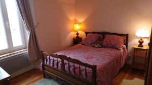 Un dormitorio con una cama con un osito de peluche. en Le Gîte du Hérisson, Gîte de charme et de confort en Le Menoux
