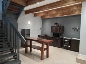 uma cozinha com uma mesa de madeira e uma escada em Howick Greendale 4 Self Catering Units Solar & Battery Back-Up em Howick