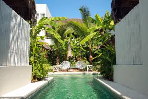 a swimming pool in a resort with two chairs and trees at Marii Hotel Boutique in San Francisco