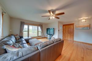 a living room with a leather couch and a ceiling fan at Cozy Lisle Home with Fenced Backyard Pets Welcome! in Lisle