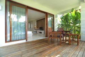 a room with a table and chairs on a deck at Living Asia Resort and Spa in Senggigi