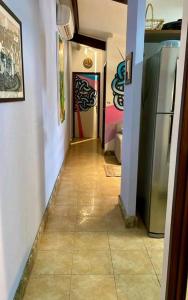 a hallway with a tile floor and paintings on the walls at Pipa's Ocean in Pipa +5 photos