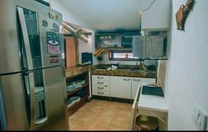 a kitchen with a refrigerator and a table in it at Pipa's Ocean in Pipa