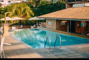 a swimming pool with chairs and a building and a building at Pipa's Ocean in Pipa