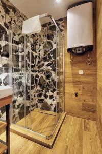 a shower in a room with a stone wall at MODERN MOUNTAIN II in Kolašin
