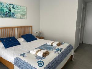 een slaapkamer met een bed met blauwe en witte lakens bij Sunny penthouse beach apartment with panoramic views in Almuñécar