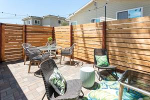 eine Terrasse mit Stühlen, einem Tisch und einem Zaun in der Unterkunft Casita Amarilla, Tiny House in San Diego