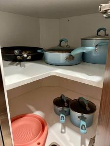 a kitchen with pots and pans on a shelf at Casita Amarilla, Tiny House in San Diego