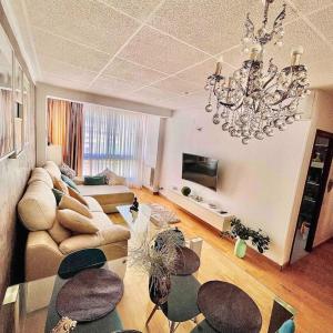 a living room with a couch and a chandelier at Premium Aparthotel-PortAventura, FerrariLand,tren in Reus