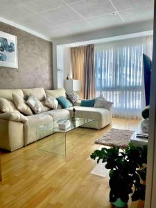 ein Wohnzimmer mit einem Sofa und einem Glastisch in der Unterkunft Premium Aparthotel-PortAventura, FerrariLand,tren in Reus