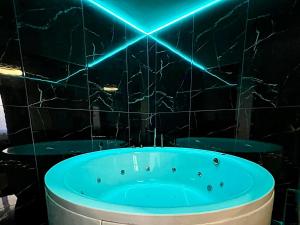 baño con bañera con luces azules en la pared en Luxor - Jacuzzi&Cozy Apartments en Sibiu