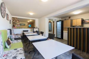 une pièce avec des tables et des chaises et une cuisine dans l'établissement Къща за гости Перуника, à Sapareva Banya