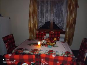 a table with a candle and a bowl of fruit on it at Domowe Zacisze w Nickulinie in Rajcza