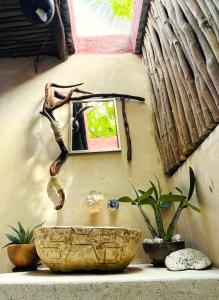 a bathroom with a stone sink and a mirror at Casa Jade Ecobungalows Las coloradas in Yuluc