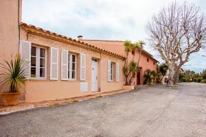 an empty street in front of a building at La Maison et son jardin clos in Porquerolles