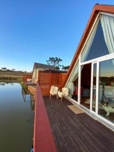a house with a wooden deck next to the water at Recanto Entre Rios in Bom Jardim da Serra