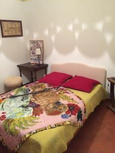 1 dormitorio con 1 cama con un edredón colorido en Lou Jas - Cassis, en Cassis