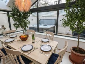 einen Tisch mit Stühlen und eine Flasche Wein darauf in der Unterkunft Palm Tree Cottage in Sandown