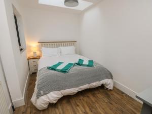 ein Schlafzimmer mit einem Bett mit zwei grünen Platten darauf in der Unterkunft Palm Tree Cottage in Sandown + 17 Fotos