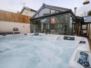 eine Whirlpool-Badewanne vor einem Haus in der Unterkunft Palm Tree Cottage in Sandown