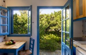 una cocina con puertas azules y una mesa con fruta en Phlea Farm Studios en Alinda