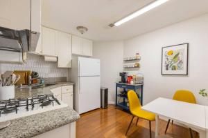 a kitchen with a stove and a white refrigerator at Emerald Guest House in San Diego