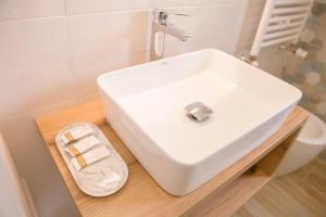 lavabo blanco sentado en una encimera de madera en el baño en A Due Passi, en Montesano Scalo
