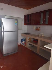 La cuisine est équipée d'un réfrigérateur blanc et de placards en bois. dans l'établissement Casa Ana, à Santiago