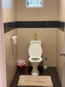 - une salle de bains pourvue de toilettes et d'un tapis au sol dans l'établissement Keris Rental Houses, à Vaitele