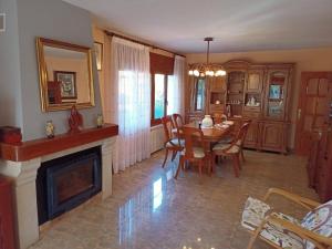 a dining room with a table and a fireplace at Casa en Parque Natural del Montseny. in Santa María de Palautordera