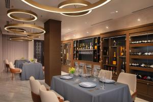 een eetkamer met 2 tafels en een wijnkelder bij Dreams Riviera Cancun Resort & Spa - All Inclusive in Puerto Morelos