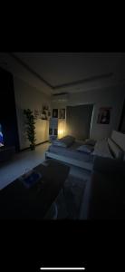 شقة أنيقة في العليا في الرياض: غرفة معيشة بها سريرين وأريكة