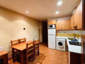 uma cozinha com uma mesa, um lavatório e uma máquina de lavar louça em Pirineos como en casa 2 em Bielsa