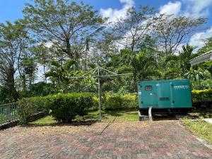 a green electrical box sitting in a yard at Keris Rental Houses in Vaitele