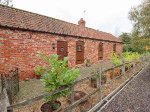 a brick house with a fence next to it at Ratty's Retreat in Spilsby