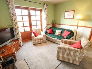 a living room with a couch and chairs and a tv at Ratty's Retreat in Spilsby