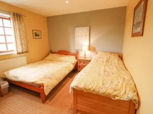 a bedroom with two beds and a lamp on a table at Ratty's Retreat in Spilsby