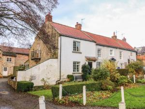 an old white house with a red roof at Malt Shovel Cottage in Bedale