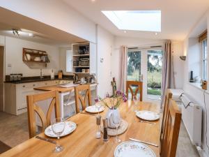 a kitchen and dining room with a wooden table at Malt Shovel Cottage in Bedale