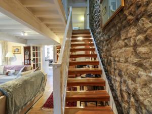 a staircase in a house with a stone wall at Malt Shovel Cottage in Bedale