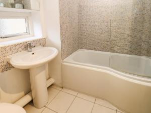 a bathroom with a sink and a tub and a toilet at Malt Shovel Cottage in Bedale +26 photos